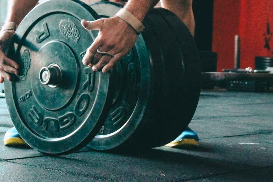 man placing weight plate on barbell