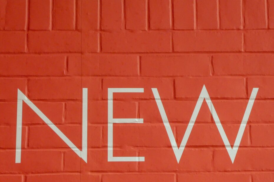 The word new on a red brick wall.